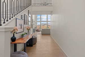 Corridor with a high ceiling and light wood-style flooring