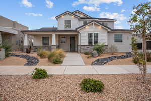 Craftsman-style house featuring stone siding and a porch
