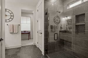 Full bath with plenty of natural light, a shower stall, and dark tile patterned floors