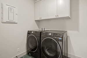 Washroom featuring washer and clothes dryer, cabinet space, and tile patterned flooring