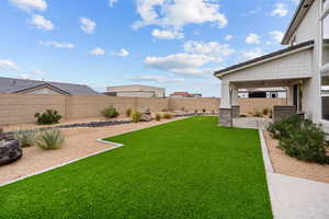 Fenced backyard featuring ceiling fan