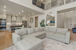 Living area featuring light wood finished floors, recessed lighting, and a high ceiling