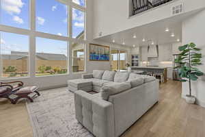 Living area with a towering ceiling and light wood-type flooring