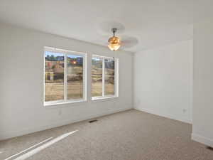 Unfurnished room with light colored carpet and a ceiling fan
