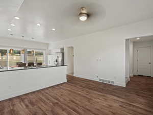 Unfurnished living room featuring recessed lighting and dark wood-style floors