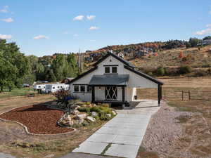 Modern farmhouse style home featuring an attached carport, covered porch, driveway, board and batten siding, and a metal roof