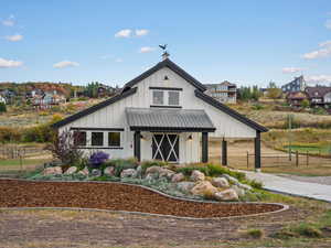 Modern farmhouse with board and batten siding, a metal roof, and covered porch