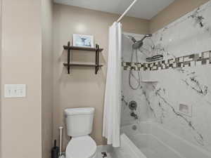 Full bath with shower / bath combination with curtain and toilet