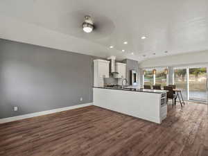 Kitchen with white cabinets, recessed lighting, dark wood-style floors, a peninsula, and decorative light fixtures