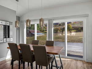 Dining room featuring light wood-type flooring and lofted ceiling