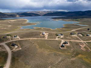 Aerial view of property and surrounding area with a water and mountain view