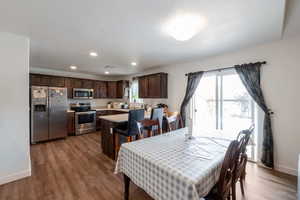 Dining space featuring dark wood-type flooring and recessed lighting