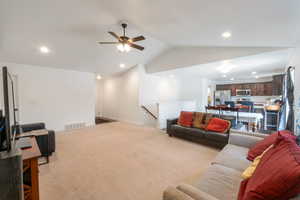 Living area with recessed lighting, lofted ceiling, light colored carpet, and a ceiling fan