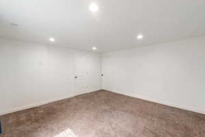 Carpeted spare room with baseboards and recessed lighting