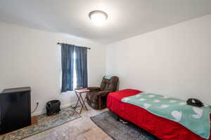 Bedroom with a textured ceiling and baseboards
