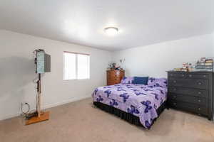 Bedroom with a textured ceiling and light carpet