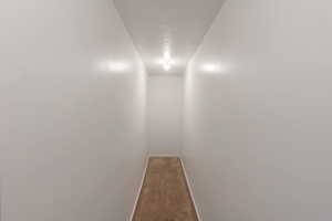 Corridor with carpet floors and a textured ceiling