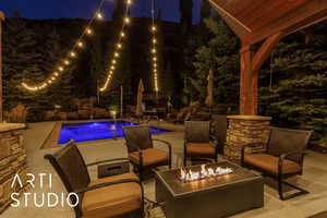 Pool at twilight featuring an outdoor pool, a patio, and an outdoor living space with a fire pit