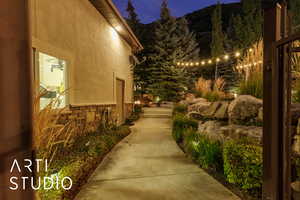Property exterior at twilight with stucco siding and stone siding