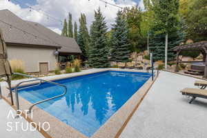 Swimming pool featuring a patio area and a pergola