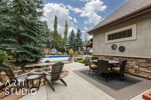View of patio / terrace featuring outdoor dining space, a fire pit, and an outdoor pool