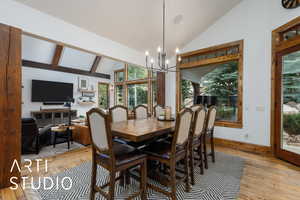 Dining room featuring a chandelier, light wood-style flooring, and high vaulted ceiling