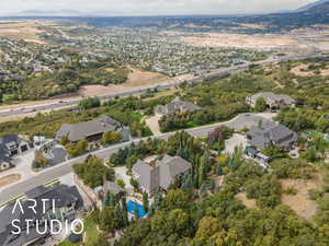 Aerial view of property and surrounding area featuring nearby suburban area and mountains