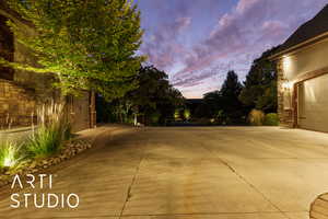 Patio terrace at dusk with a garage and concrete driveway