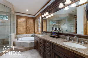 Bathroom with a bath, a stall shower, double vanity, and ornamental molding