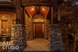 Entrance to property featuring stone siding and a porch