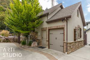 View of front of house with roof with shingles, stone siding, stucco siding, concrete driveway, and an attached garage