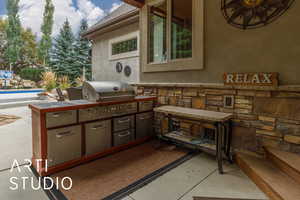 View of patio with an outdoor kitchen and an outdoor pool