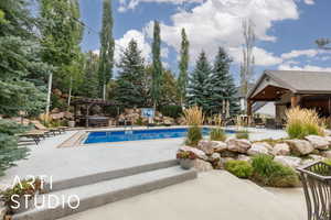 Swimming pool featuring a patio and a jacuzzi