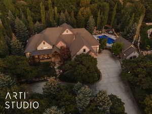 Aerial view of property and surrounding area featuring a forest