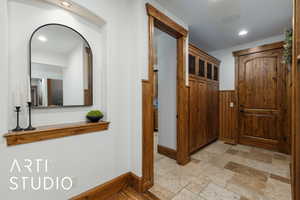 Hallway with recessed lighting and stone tile flooring