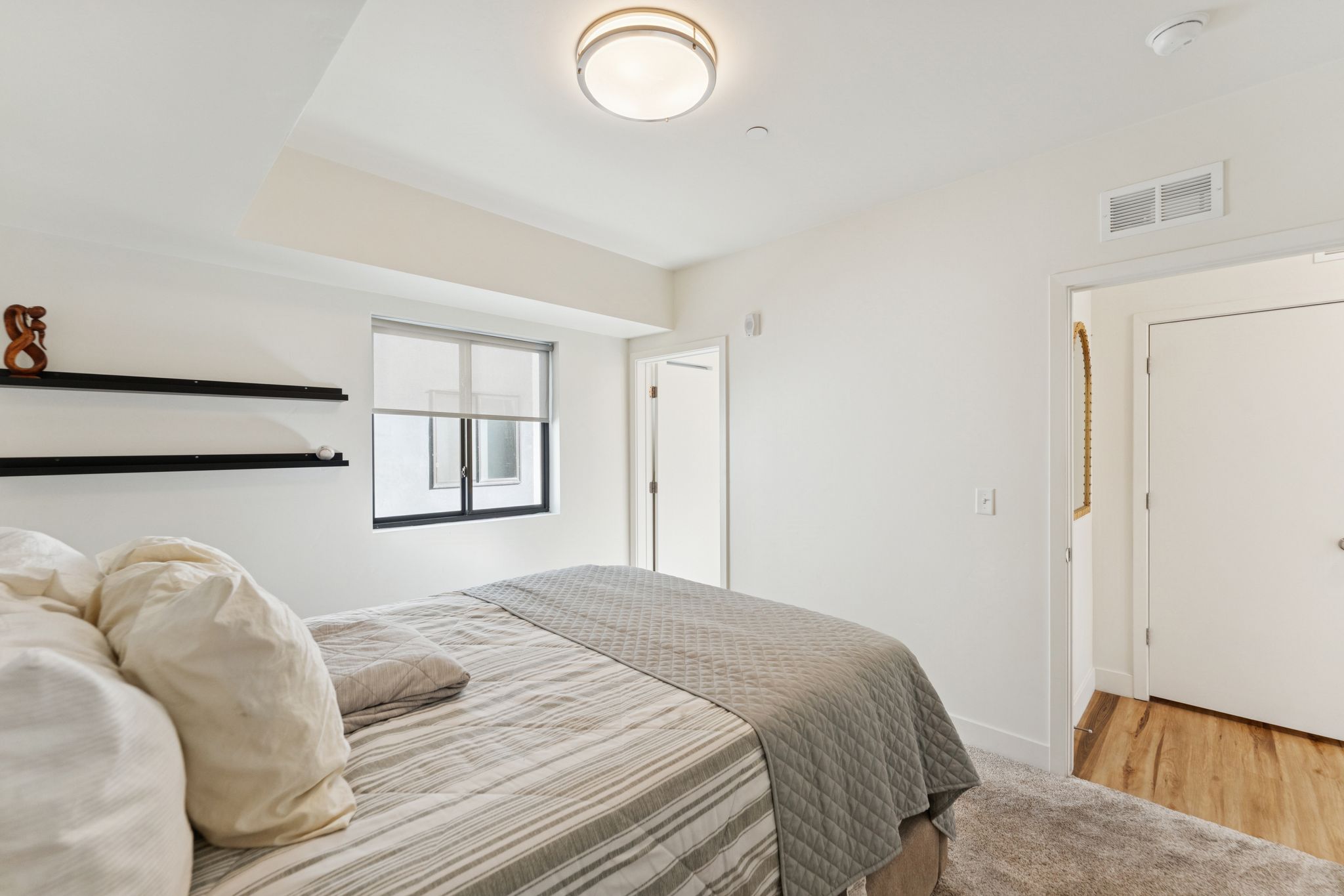 Bedroom featuring light colored carpet and light wood-type flooring