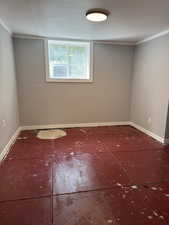 Empty room featuring baseboards and crown molding