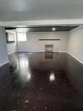 Unfurnished living room featuring dark wood finished floors and a brick fireplace