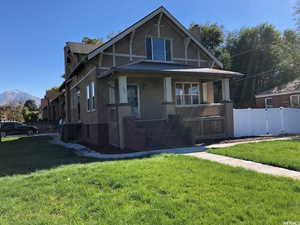View of front of home featuring covered porch, stucco siding, a chimney, and a mountain view