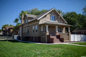 View of front of house with covered porch, a chimney, a shingled roof, stucco siding, and stairway
