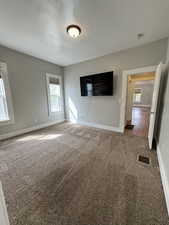 Carpeted empty room featuring baseboards