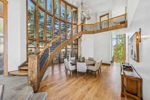 Dining room with a high ceiling, a chandelier, hardwood / wood-style flooring, stairs, and recessed lighting