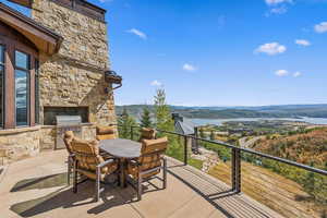 Balcony featuring exterior kitchen, outdoor dining area, and a water and mountain view