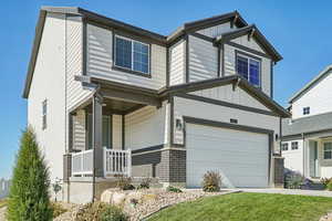 Craftsman-style house featuring board and batten siding, covered porch, concrete driveway, brick siding, and an attached garage
