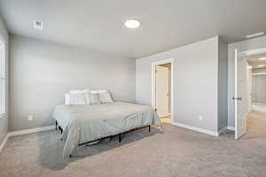 Bedroom featuring light carpet and baseboards