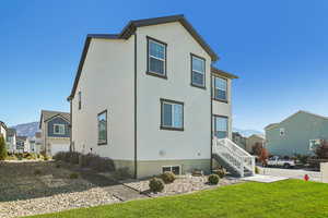 Back of property with a residential view, a yard, stucco siding, and a mountain view