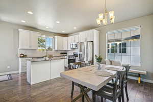 Dining room with recessed lighting, dark wood-style floors, and a chandelier