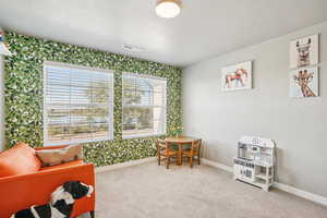 Rec room with wallpapered walls, light carpet, and a textured ceiling