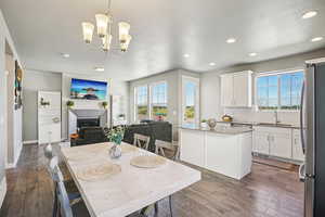 Dining space with a glass covered fireplace, light wood finished floors, plenty of natural light, and recessed lighting