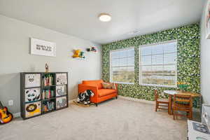 Living area featuring carpet flooring and wallpapered walls